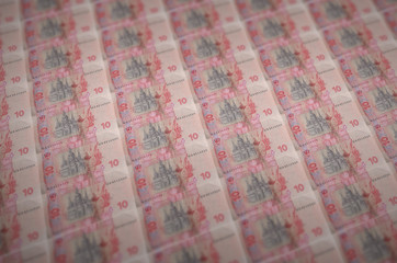 10 Ukrainian hryvnias bills printed in illegal money production conveyor. Collage of many fake...