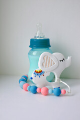 Large silicone clip for baby pacifier and milk bottle on white background. Soft toy in the form of an elephant. Beautiful accessories for a newborn. The concept of happy motherhood and childhood.