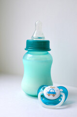 Photo of a baby bottle with breast milk. The concept of a happy childhood and motherhood. Photo on a white background. Support for breastfeeding.