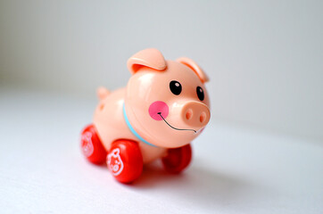 A very small plastic mechanical pink pig toy. Wind-up toy-pig on a white background.