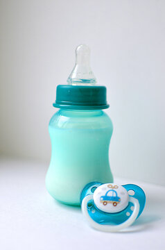 Photo of a baby bottle with breast milk. The concept of a happy childhood and motherhood. Photo on a white background. Support for breastfeeding.