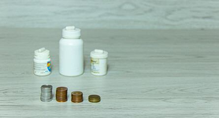 pills and pennies on the table. There is a shortage of money because of buying too much medicine.