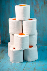 small pyramid of toilet paper on a blue background