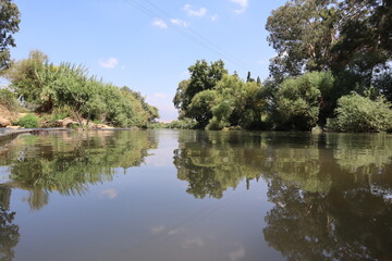 Fototapeta na wymiar A mirror image of the Jordan River in the Kfar Blum Dam in Israel