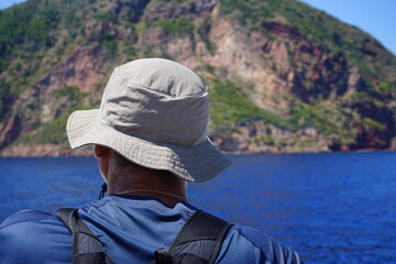 Turista di spalle guarda verso l'arcipelago delle isole Eolie, nel mar mediterraneo, Sicilia, Italia