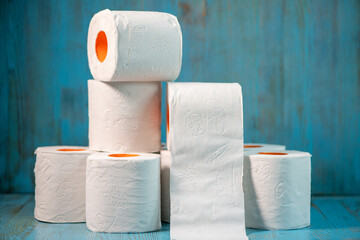 small pyramid of toilet paper on a blue background