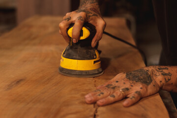 Mano con lijadora en madera