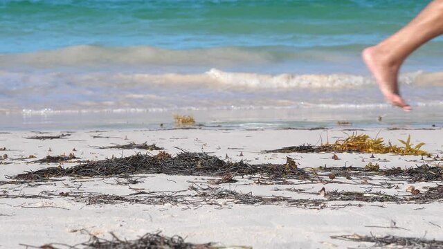 Beautiful woman legs, walking along the beach. Leaving footprints on sand. Bavaro beach. Punta Cana. Dominican Republic
