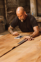 Carpintero mexicano trabajando en talle con tableta