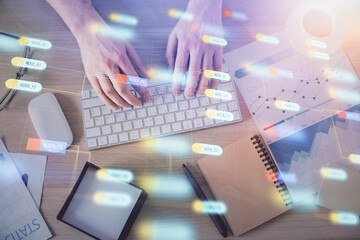 Double exposure of man's hands typing over computer keyboard and data theme hologram drawing. Top view. Technology concept.
