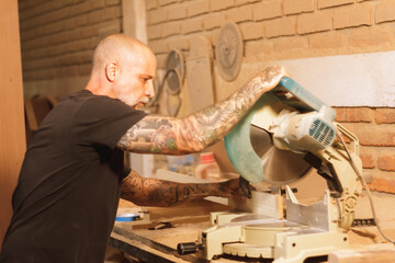 Hombre mexicano latino trbajando con sierra electrica manual cortando madera