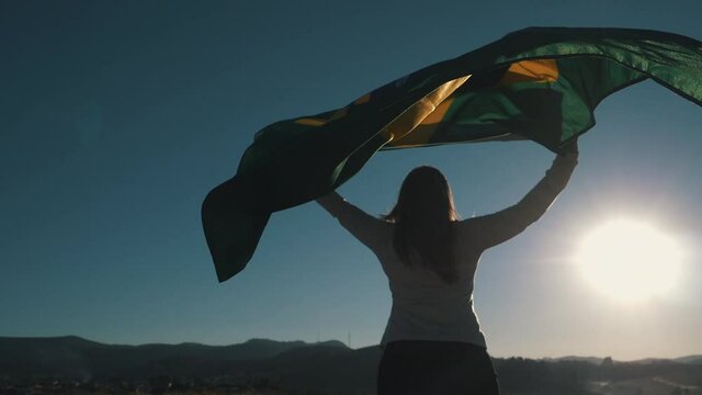 Woman walking with Brazilian flag, independence day - slow motion