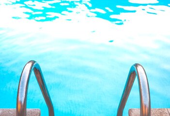 Metal stairs of a salt water pool on a summer day.