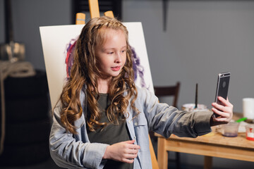 a young blogger broadcasts from an art Studio where she draws an abstract picture