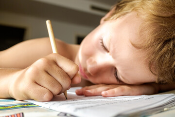 Boy tries to study and do his homework during the summer holidays.