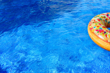 Fototapeta na wymiar Detail with copy space of a round float in a pool with clean and refreshing waters, background with negative space for summer.