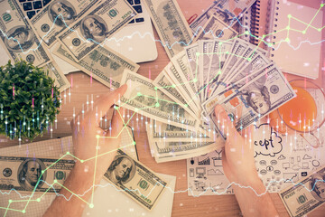 Multi exposure of financial graph drawing hologram and USA dollars bills and man hands. Analysis concept.