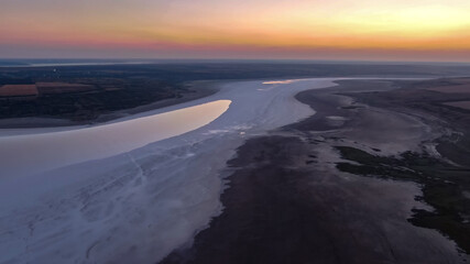 atmospheric sunset in yellow-pink tones in a valley on a salt marsh