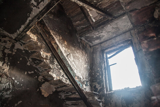 Broken shabby window in an abandoned house. In a room littered with old rubbish