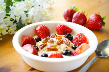 Strawberry yoghurt parfait on wooden table 