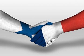 Handshake between france and finland flags painted on hands, illustration with clipping path.