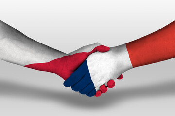 Handshake between france and poland flags painted on hands, illustration with clipping path.