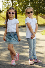 Two sisters pose for the camera outdoors in a Sunny Park. Selective focus