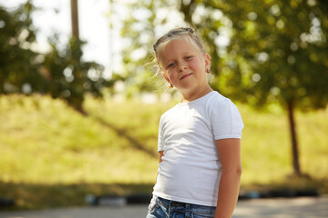 Portrait of a little girl in a white t-shirt in the Park Sunny day