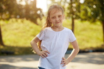 Portrait of a little girl in a white t-shirt in the Park Sunny day