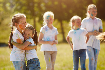 Fototapeta premium Friends having fun with powder paint on a sunny day. Selective focus