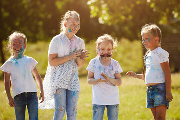 Fototapeta premium Friends having fun with powder paint on a sunny day. Selective focus