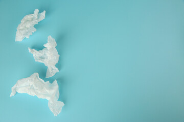 Used paper tissues on light blue background, flat lay. Space for text