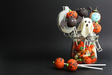 Delicious Halloween themed cake pops on black background, space for text