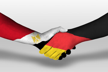 Handshake between germany and egypt flags painted on hands, illustration with clipping path.
