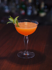 Mojito variation using dark run and bitters on a wooden bar top