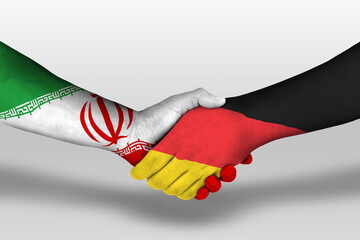 Handshake between germany and iran flags painted on hands, illustration with clipping path.