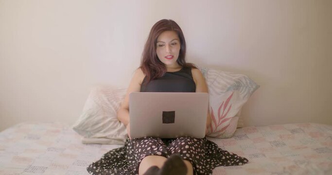 A Hispanic Woman Is Smiling And Waving By Video Call On A Laptop Computer 