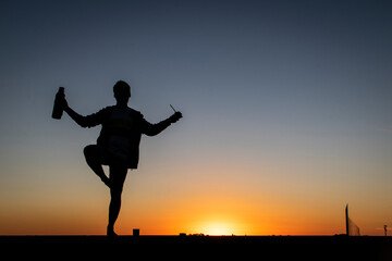silhouette of a man on a pier at sunset