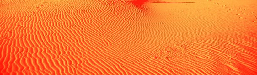 Sand ripples caused by the wind with vivid colors orange and red