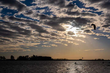 silhouette of a man windsurfing on the beach