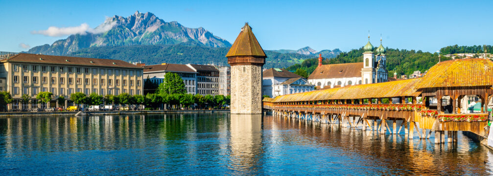 Scenic panoramic view of Lucerne with Chapel bridge or Kapellbrucke and Pilatus mount with clear blue sky during summer Lucerne old town Switzerland