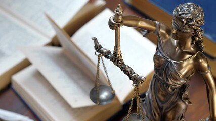 Unrecognizable lawyer's hand works with papers and law books in courtroom or office. Concept of justice and law, attorney or court judge