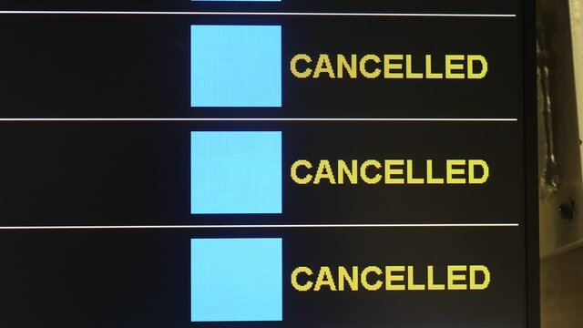 Cancelled flights on time schedule board. Airport terminal near check in counter. Preventive measures to reduce spread of disease during coronavirus pandemic, new normal reality