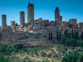 Obraz premium walled village in Tuscany, Italy with medieval towers, buildings, trees, and greenery