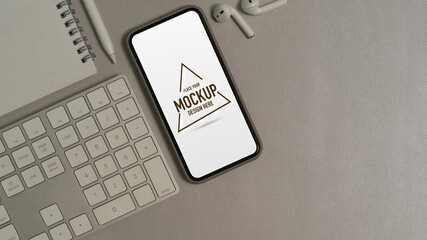 Office desk with mock up smartphone, computer keyboard, notebook, accessories and copy space