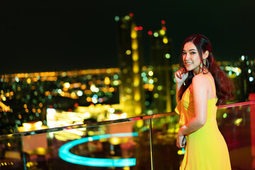 woman in evening dress over night city background