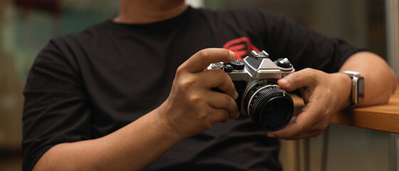 Male photographer holding digital camera in studio