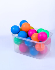colored balls in plastic basket isolated white background