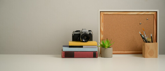 Workplace with copy space, books, camera, stationery and decorations in home office