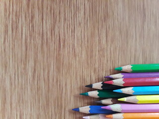 Fototapeta premium Arrangement of colored pencils on wooden background. copy space for text. back to school concept. rustic vintage concept